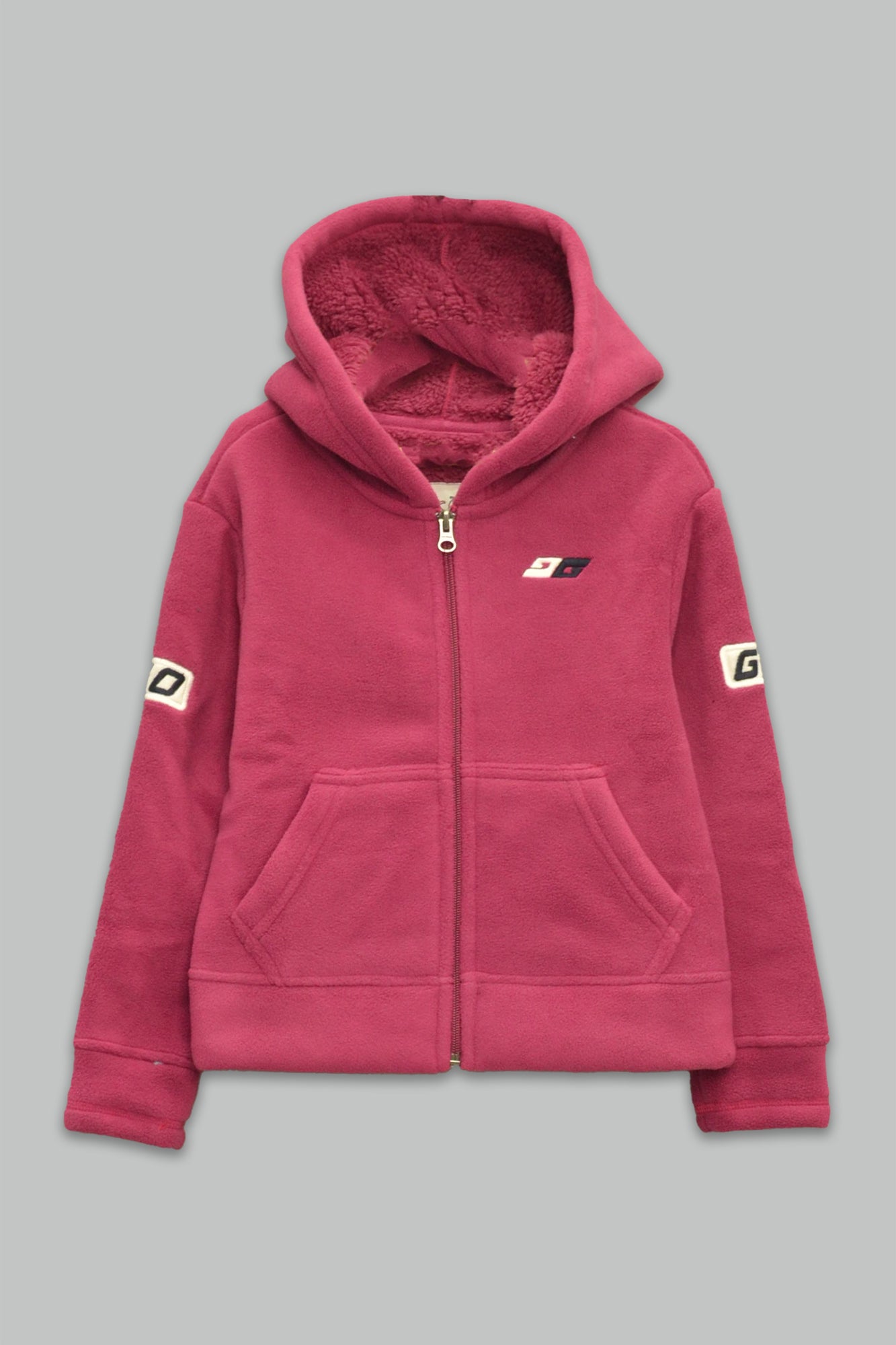 Sudadera sherpa niña bordada con manga larga, capucha ajustable, bolsas frontales y cierre.