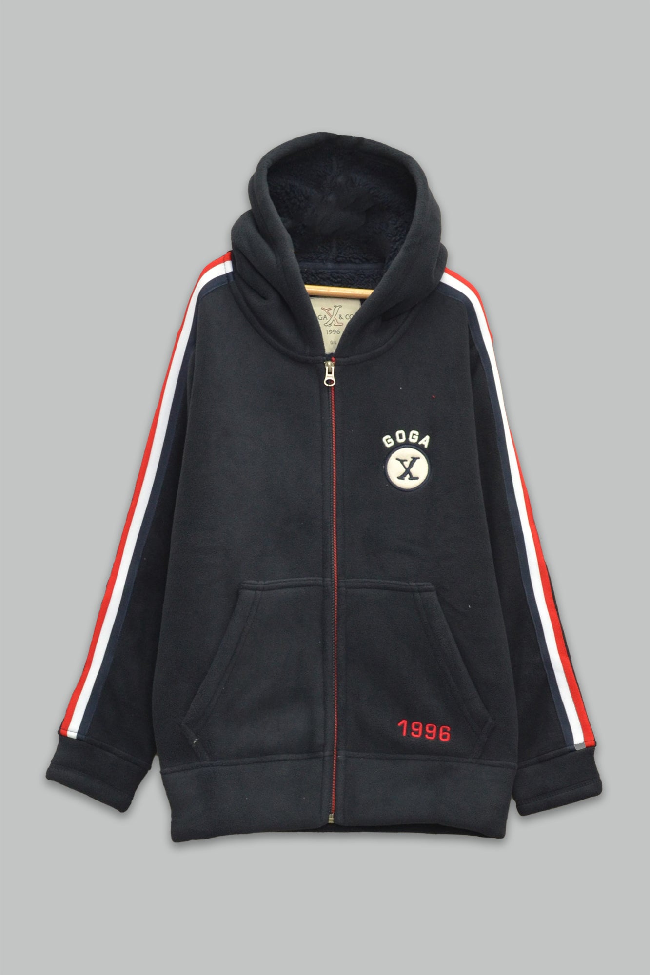 Sudadera sherpa niño bordada con manga larga, capucha ajustable, bolsas frontales y cierre.